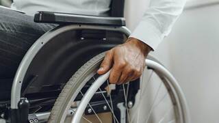 person in green shirt with American flag badge and hand on their heart