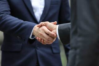 two people in suits shaking hands